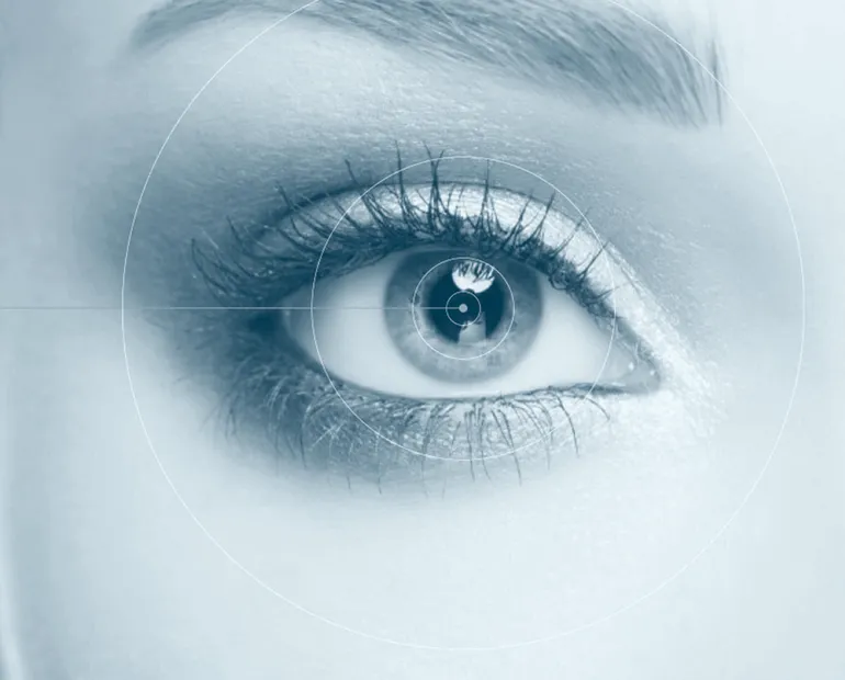 Photo d'un visage zoomé sur l'œil droit avec des traits partant de la rétine rappelant des lasers