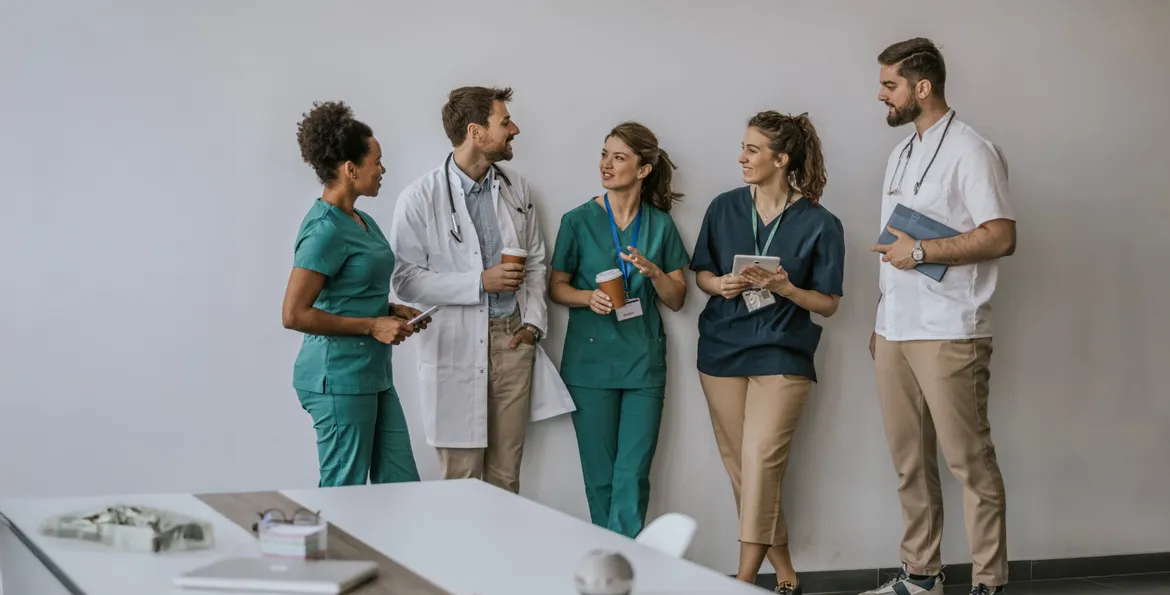 Une équipe médicale debout contre un mur qui discute ensemble