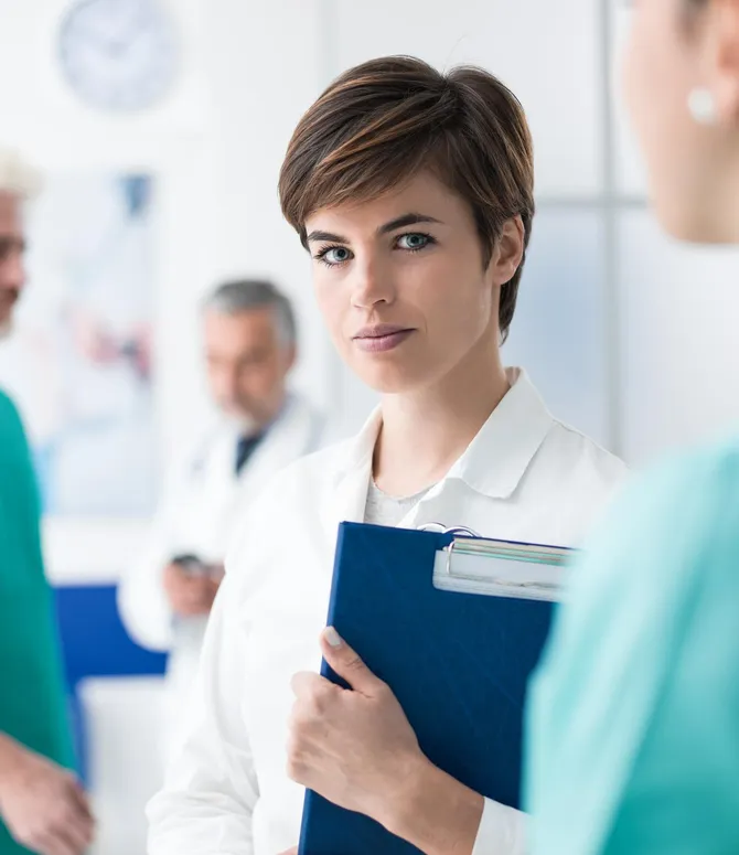 Photo of a department manager in a lab coat holding a job application folder