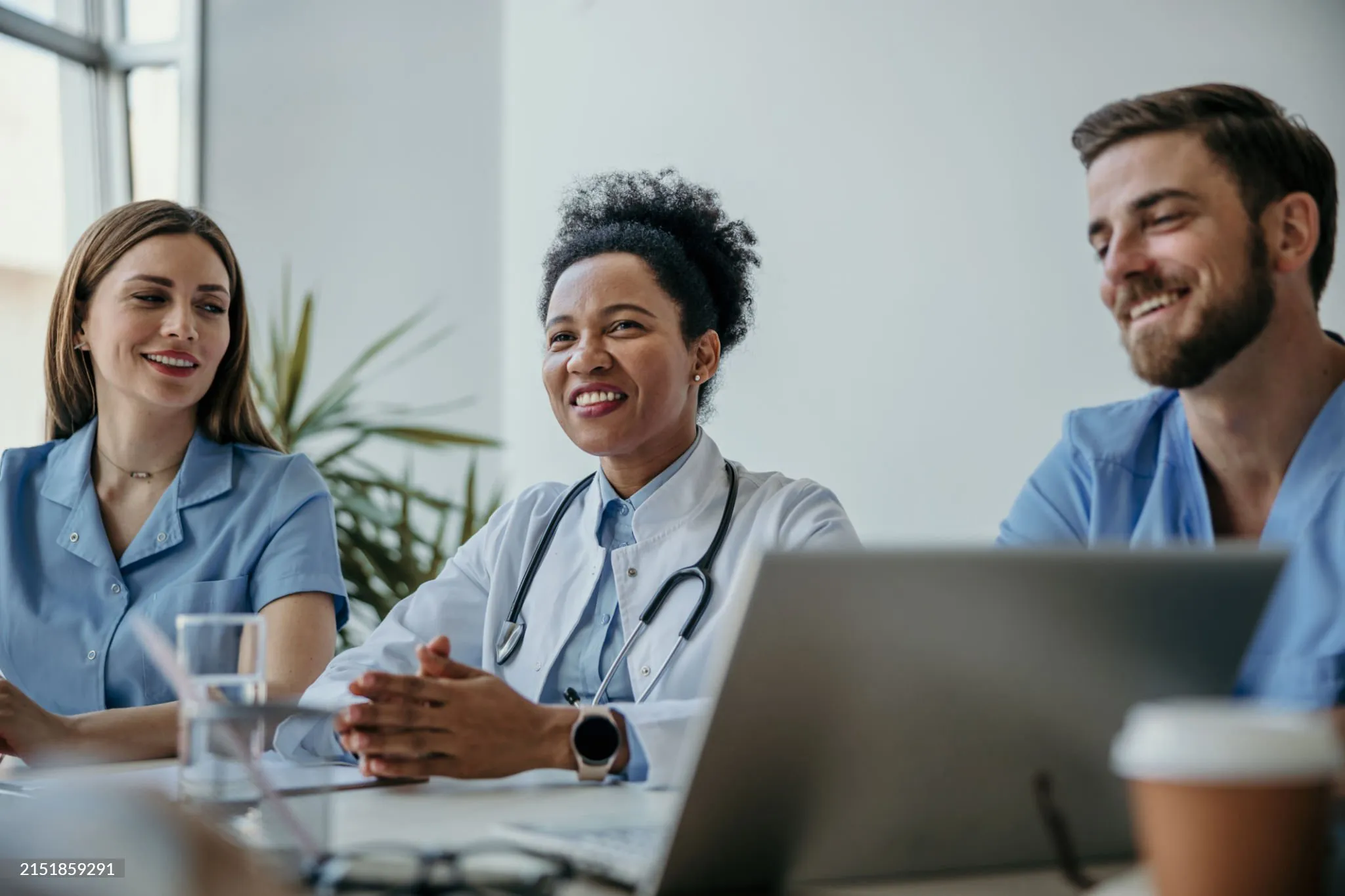 Médecin femme souriante lors d'une réunion autour d'un bureau